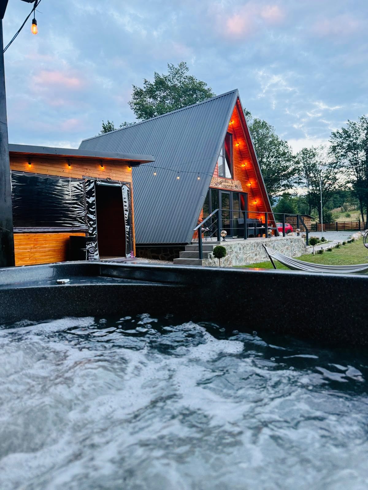 Cabana Munceluș la apus, văzută din ciubăr, cu luminile aprinse